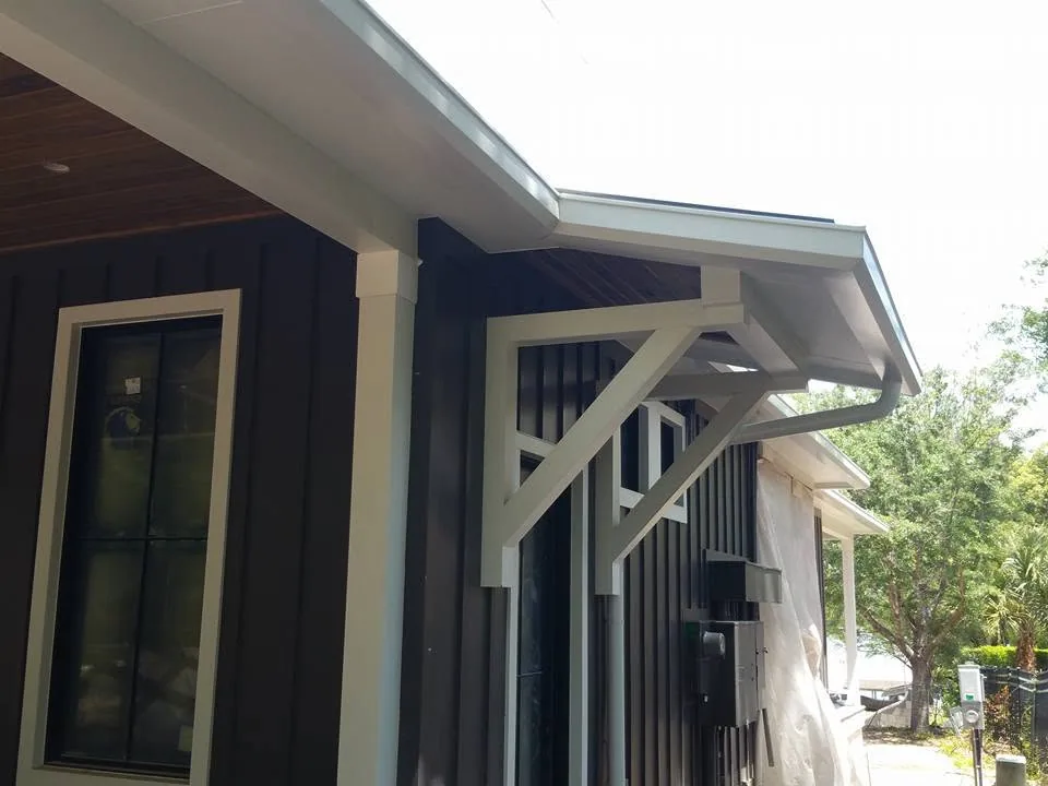White gutter bracket awning dark board batten siding, Sanford